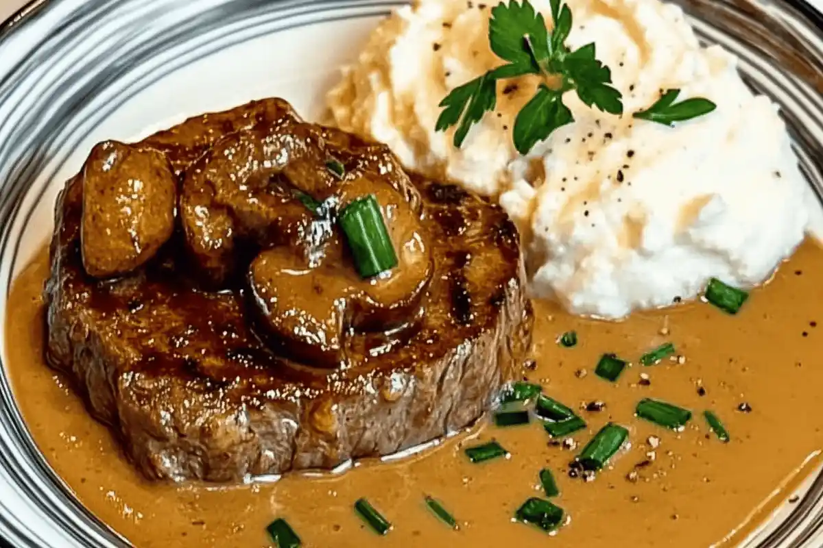 "Steak Diane served with creamy sauce and garnished with parsley on a white plate."