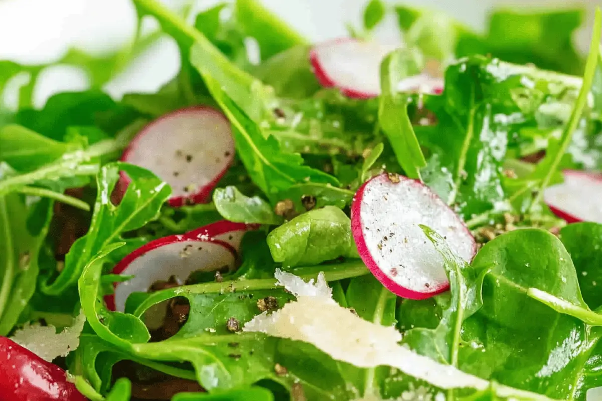 "Fresh rocket salad with arugula, cherry tomatoes, and Parmesan on a wooden table."